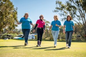 Four women walking and enjoying a corporate golf day event. Captured by Light Planning Media, showcasing candid event photography and videography